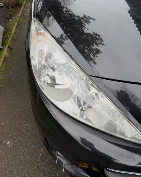 Phare avant d'une Peugeot 207 noire après polymérisation de l'optique
