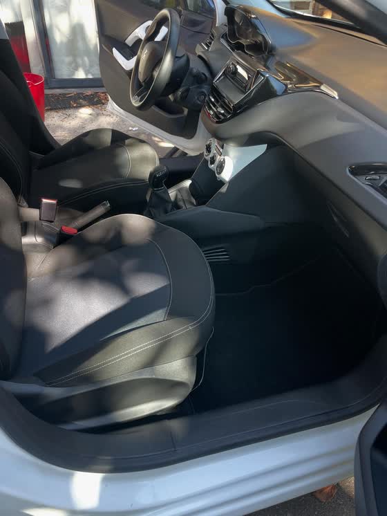 Le même intérieur de Peugeot 208 après nettoyage complet : sièges et moquette propres